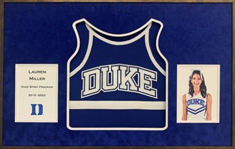 Framed Duke cheerleading uniform and photo display.