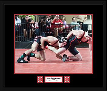 Wrestlers competing on a red mat.