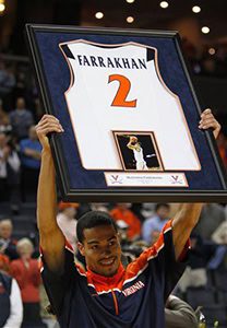 Man holding framed basketball jersey, number 2.
