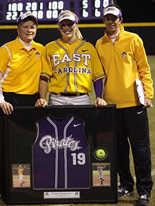 Three people with framed sports jersey.