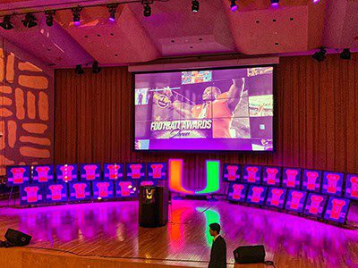 Football awards stage with colorful lighting.