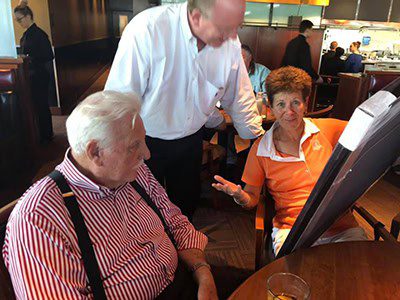 Three people conversing at a restaurant table.