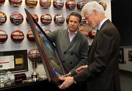 Two men examining a framed picture together.