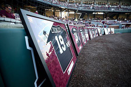 Framed baseball jerseys displayed at stadium.