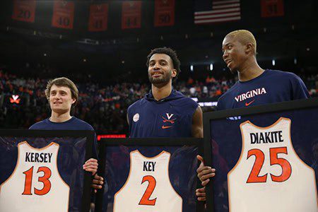 Three Virginia basketball players holding framed jerseys